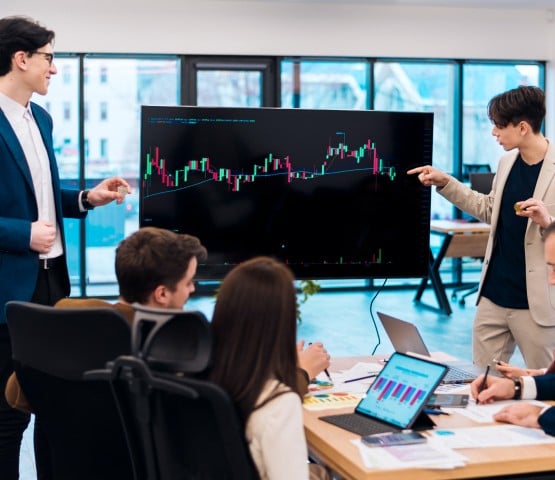 Photo of employees giving a presentation while their fellow employees watch.